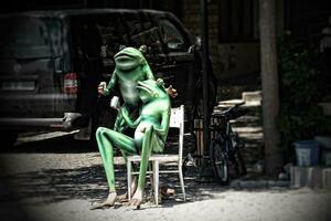 staty av grön grodor dricka turkiska te i de stad foto