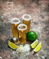 tequila i en skott glas av salt och kalk skivor. foto
