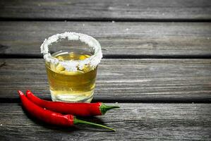 tequila i en glas av salt och varm peppar baljor. foto