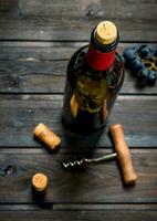 flaska av röd vin med vindruvor. foto