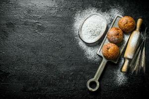 doftande bullar med mjöl och rullande stift. foto