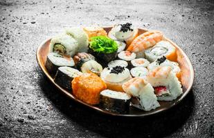 annorlunda typer av sushi rullar på de tallrik. foto