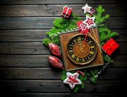 retro klocka med jul dekorationer och grön gran grenar. foto