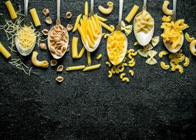 de räckvidd av annorlunda typer av torr pasta i skedar. foto