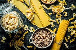 pasta bakgrund. annorlunda typer av torr pasta i de pott och skål. foto