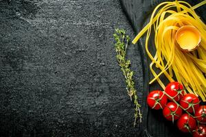rå hemlagad pasta med timjan, ägg och tomater. foto