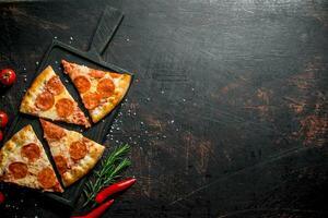 skivor av pepperoni pizza med chili, rosmarin och körsbär tomater. foto