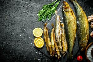 rökt fisk med dill, citron- skivor och vitlök kryddnejlika. foto