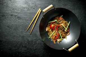 kinesisk wok. varm asiatisk cellofan spaghetti i en fräsning panorera wok. foto