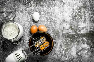 bakning bakgrund. blandning ägg med en mixer till göra en deg. foto