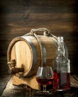 cognac i en tunna med en glas. foto