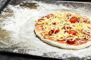 oförberedd pizza med Ingredienser. foto