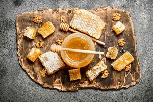 färsk honung i en burk och vaxkaka med nötter. foto