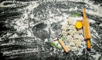 hemlagad färsk ravioli med ägg, en rullande stift och kniv. foto