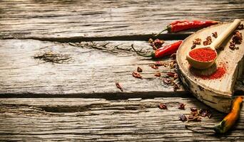 torkades och jord röd chili peppar på ek stå. foto