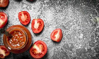 tomat sås i glas burk med sked. foto
