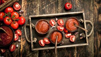 tomat sås med kryddor och vitlök i de gammal bricka. foto