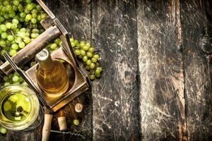 vin bakgrund. vit vin på en stå med grenar av färsk vindruvor. foto