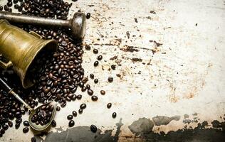 spannmål rostad kaffe i en murbruk med mortelstöt. foto