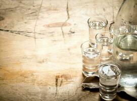 flaska av vodka med skott glasögon. foto