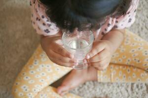 barn hand innehav en glas av vatten foto