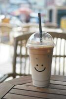 kall kaffe i en plast behållare med leende form design på den foto
