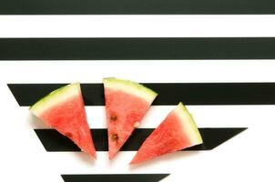 färsk röd vattenmelon skiva på randig bakgrund. sommar begrepp. topp se, platt lägga. - bild foto