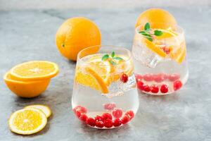 hård seltersvatten cocktail med orange, tranbär och mynta i glasögon på de tabell. alkoholhaltig dryck foto