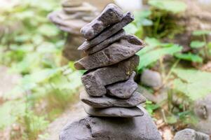 närbild av en stack av stenar i perfekt balans i en berg skog. sten pyramid, sten balansering konst. meditation, balans, fred. hobby. foto