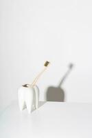 miljövänlig bambu tandborste i en tandformad stå. medveten konsumtion och dental vård begrepp. foto