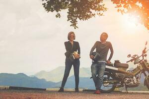 par innehav säkerhet hjälm Sammanträde på små enduro motorcykel mot skön naturlig berg scen på khaoyai nationell parkera thailand foto