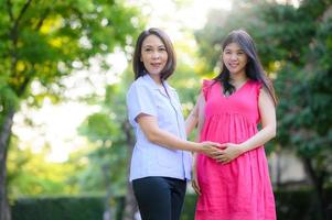 asiatisk sjuksköterska och gravid kvinna foto