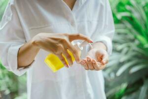 kvinna använder sig av alkohol antiseptisk gel till rengöring hand foto