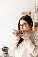 kvinna som brygger kaffe i kaffekanna, luktar gröna kaffebönor