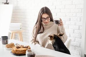 ung kvinna som dricker varmt svart kaffe sitter vid det vita bordet