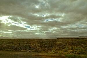 tömma mystisk bergig landskap från de Centrum av de kanariefågel ö spanska fuerteventura med en molnig himmel foto