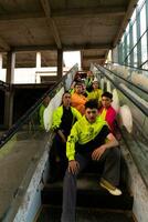 en grupp av asiatisk män är avkopplande på de trappa med deras vänner på en universitet foto