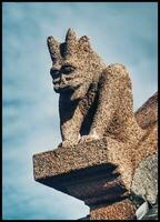 rosa granit person med groteskt ansikte detalj av en charmig kyrka i ploumanach, brittany foto