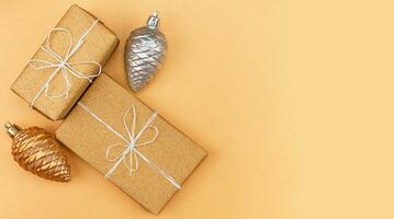 gåvor i guld förpackning, jul träd dekorationer - två koner guld och silver- på en guld bakgrund foto