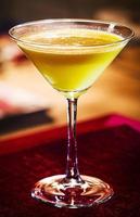 limoncello citroncreme martini blandad cocktaildrink i glas inuti mysig bar foto
