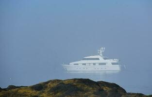 Yacht förankrade i de dimma i casco bukt foto