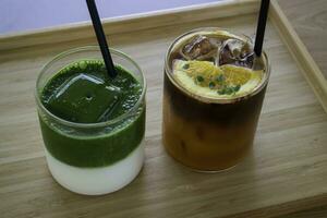 iced matcha grönt te och iced svart orange kaffe på trä- tabell foto