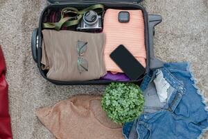 arrangemang av kläder och Tillbehör i en resväska, resor begrepp. foto