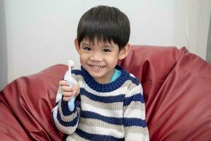 asiatisk pojke pensling hans tänder på de levande rum foto