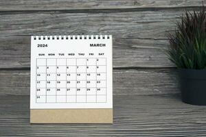 vit Mars 2024 kalender på trä- skrivbord. 2024 ny år begrepp foto