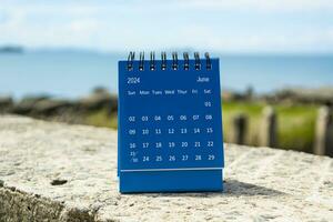 blå juni 2024 kalender på suddig bakgrund av blå hav. foto