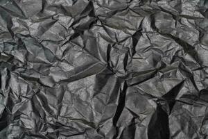 närbild detalj svart Färg bakgrund från ark av skrynkliga kartong, abstrakt textur rynkig kartong material mönster bakgrund foto