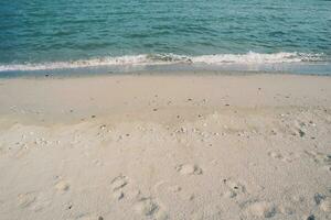 fotspår i de sand, landa scape av strand och hav, blå Vinka och vit sand foto