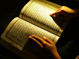 muslimsk läsande koran foto