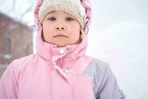en flicka i vinter- kläder står på de gata. foto